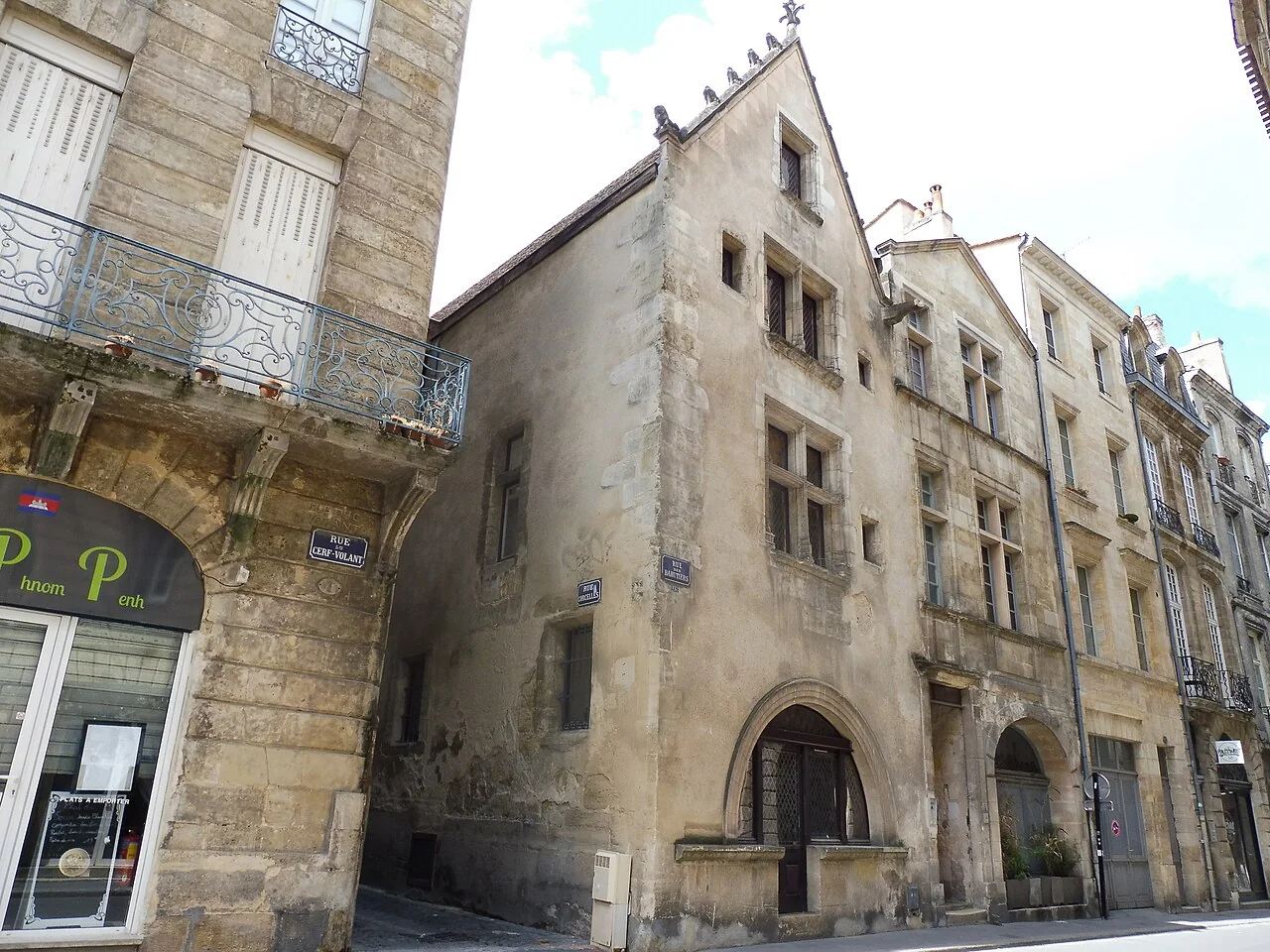 La rue des Bahutiers à Bordeaux, sa maison gothique du XVe siècle et sa plaque de rue, dans le quartier Saint-Pierre où se font face deux friperies