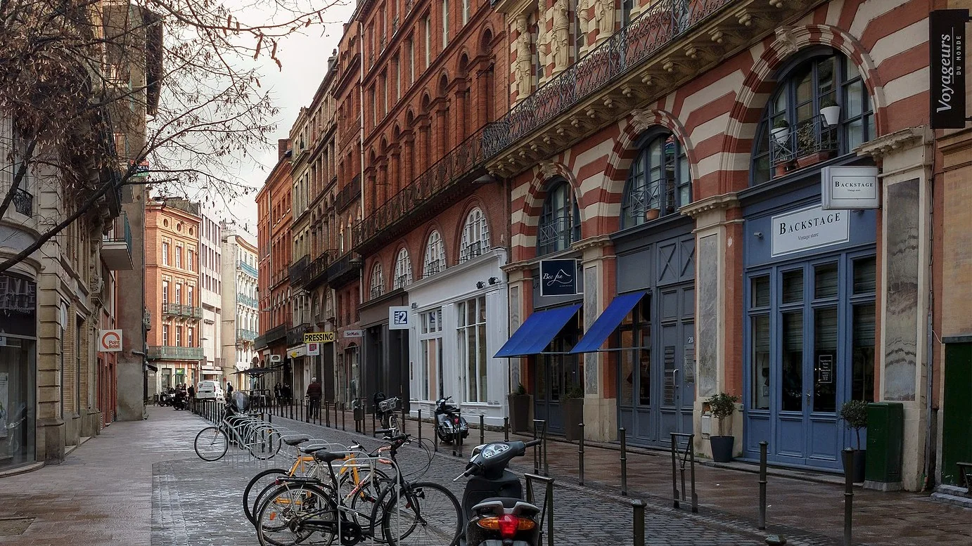 La devanture bleue de Backstage Vintage Store au 28 rue des Marchands à Toulouse, sous une façade de briques rouges et blanches, à 80 mètres du métro Esquirol