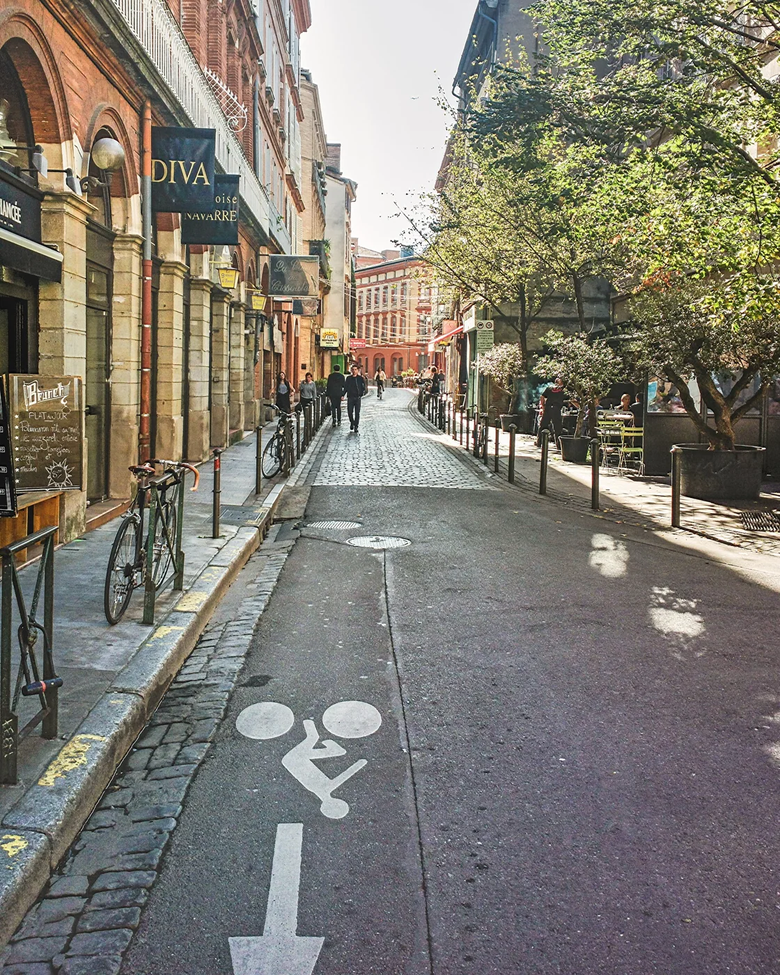 La rue Peyrolières à Toulouse, pavée et bordée de boutiques, où se trouvent la friperie au kilo Kilostock et Le Grenier d'Anaïs