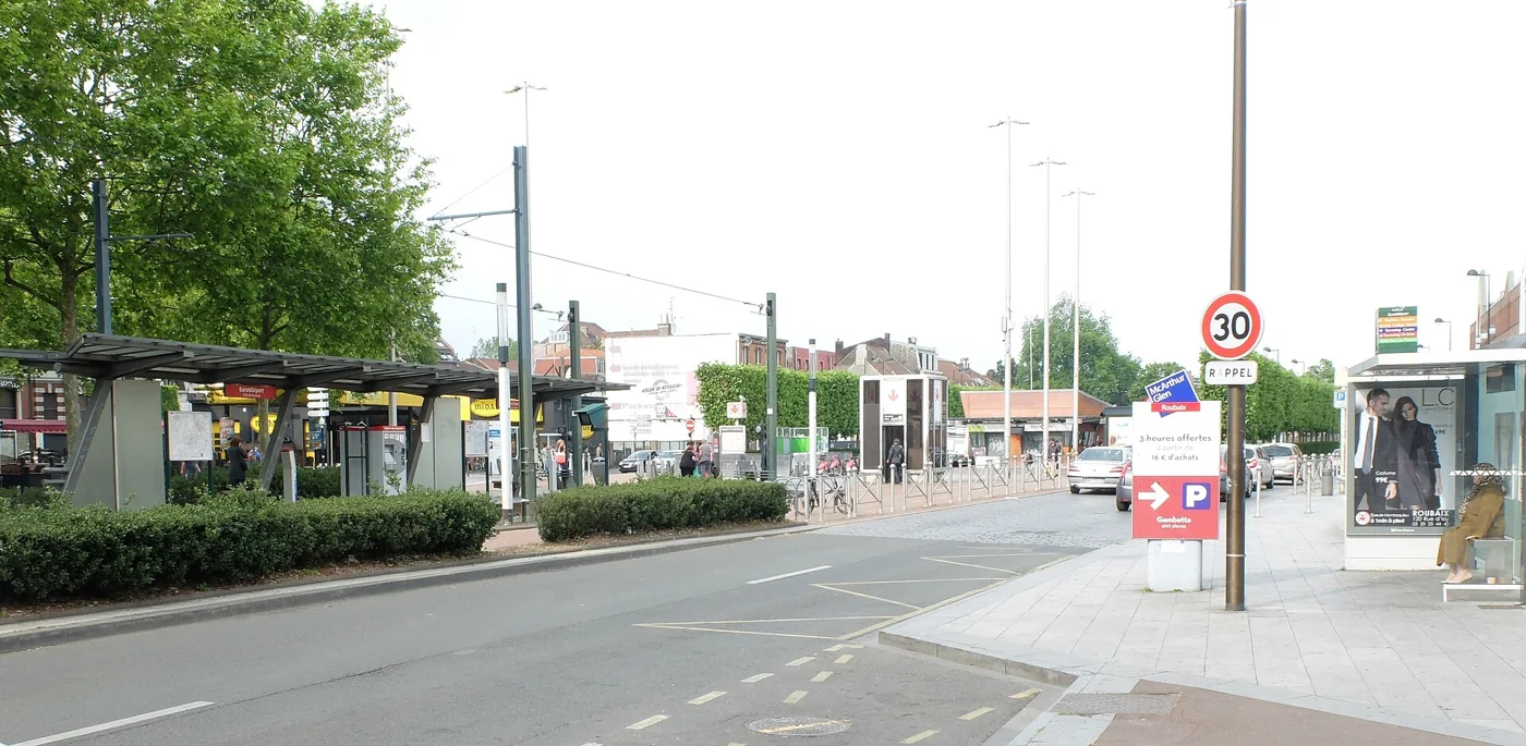 La station Eurotéléport à Roubaix, avec l'abri du terminus du tram R, l'accès au métro et un panneau fléchant le parking du McArthurGlen Roubaix